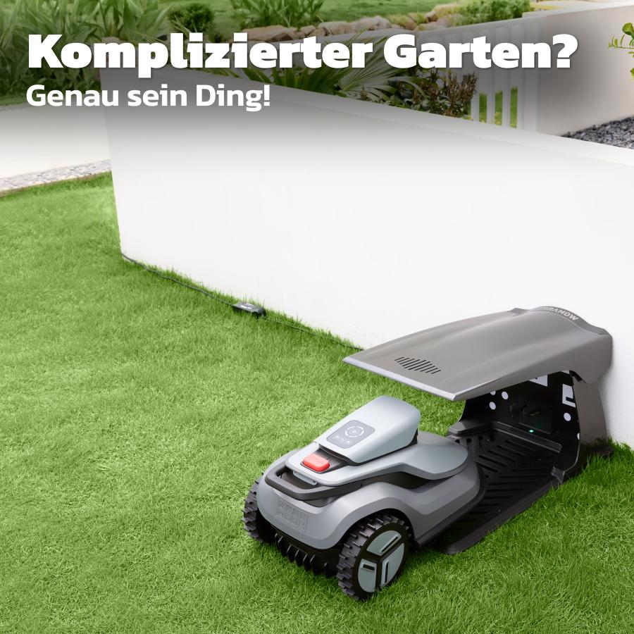 TerraMow Mähroboter in seiner Ladestation mit Dach an einer Gartenmauer