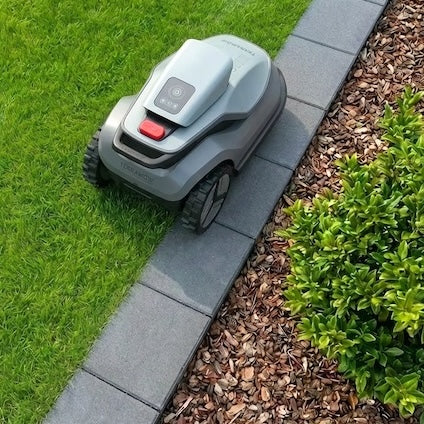 TerraMow Mähroboter fährt sauber an einer Rasenkante aus Pflastersteinen entlang